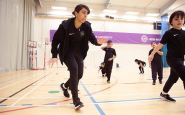 11 Female coach running with players